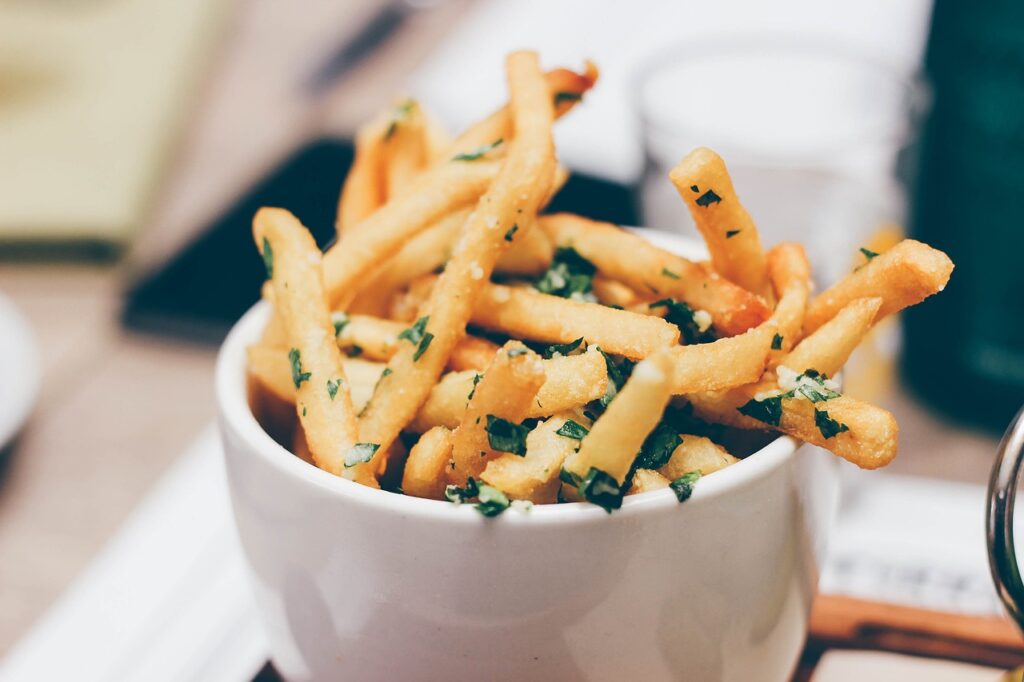 bowl of french fries with parsley on top